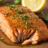 Decadent Honey Butter Glazed Salmon with caramelized crust and fresh herbs on a rustic wooden surface